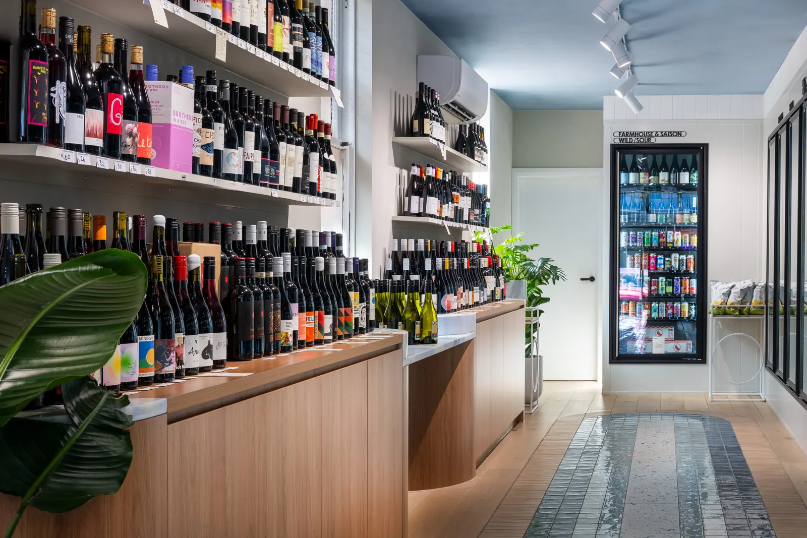 The main aisle, with timber display joinery, a blue counter front and the tiled path running to the rear of the store