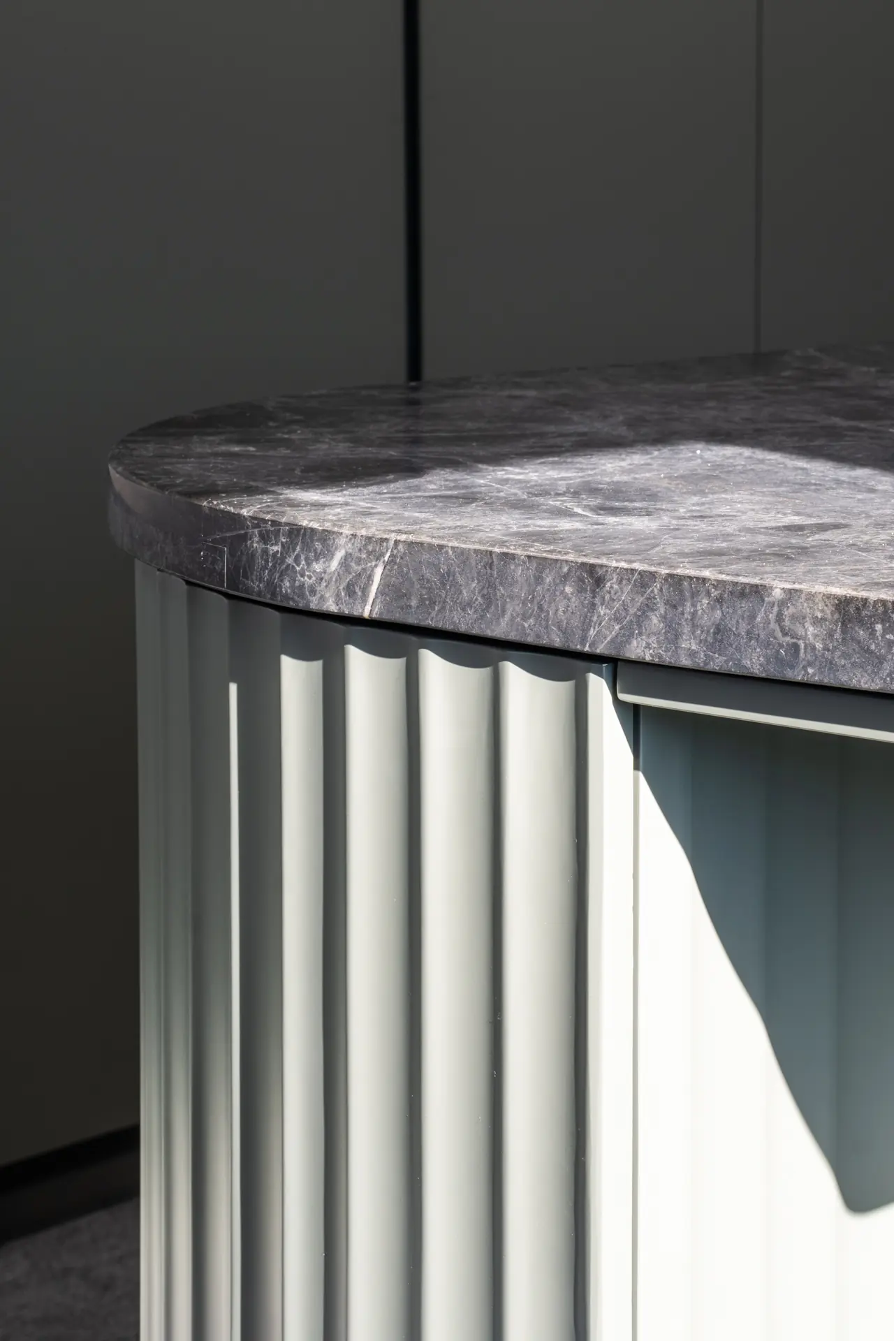 Fluted island end below a grey stone benchtop