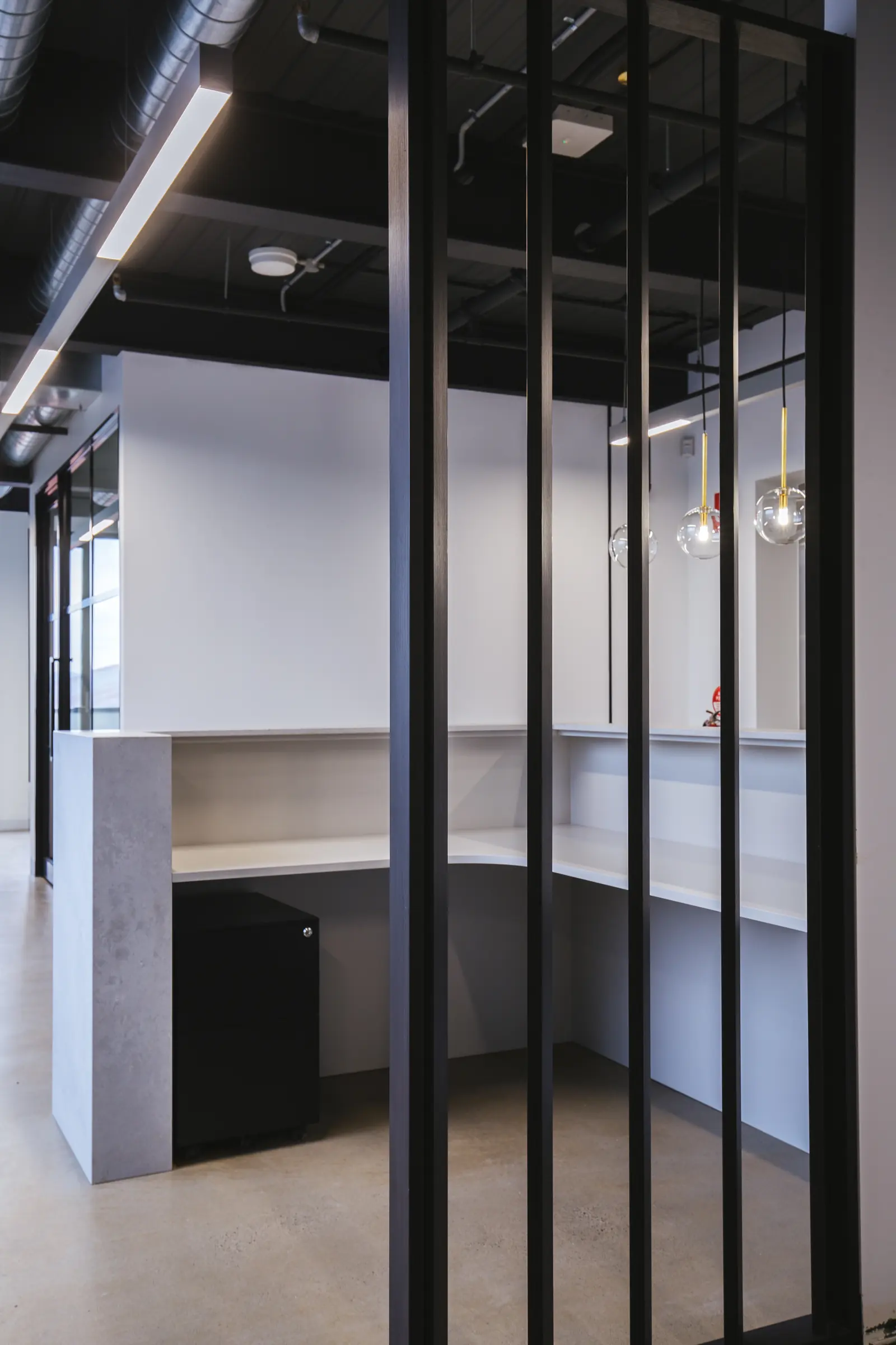 Slatted black steel screen beside the stone reception counter